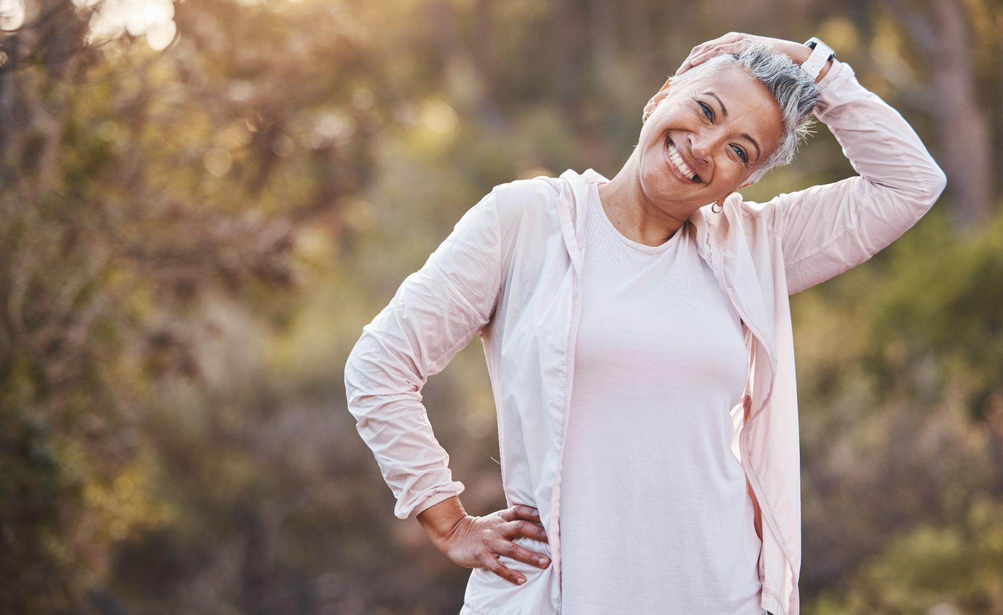 Woman stretching outdoors during menopause fitness and wellness routine.