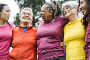 Women over 40 supporting each other outdoors, representing metabolism and healthy aging.